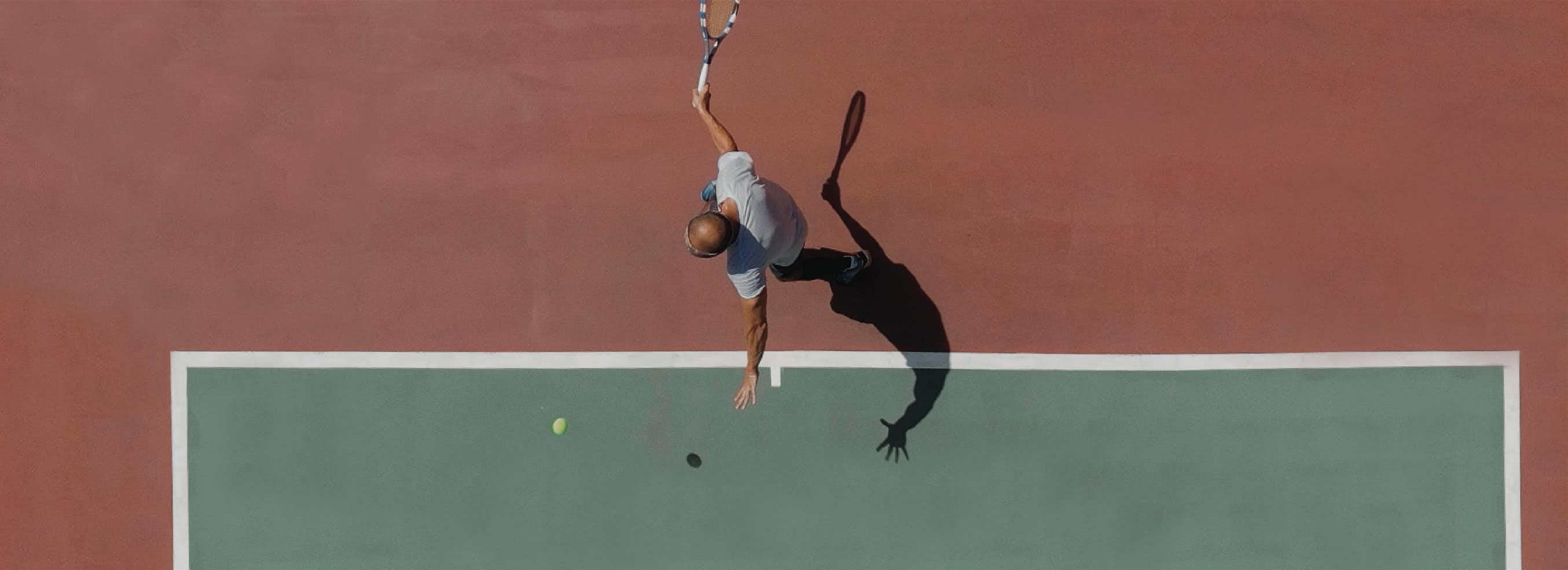 A man swings at a tennis ball.