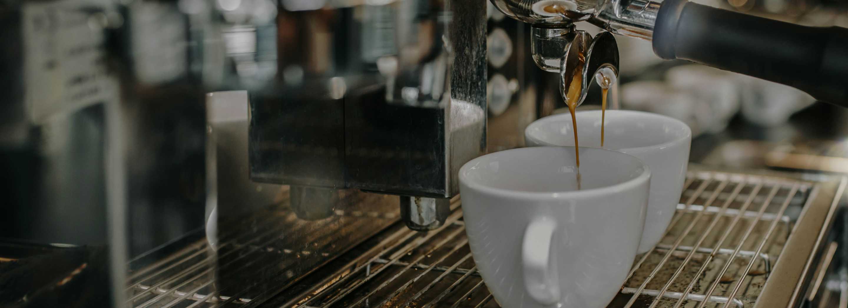 espresso pours into a white espresso cup