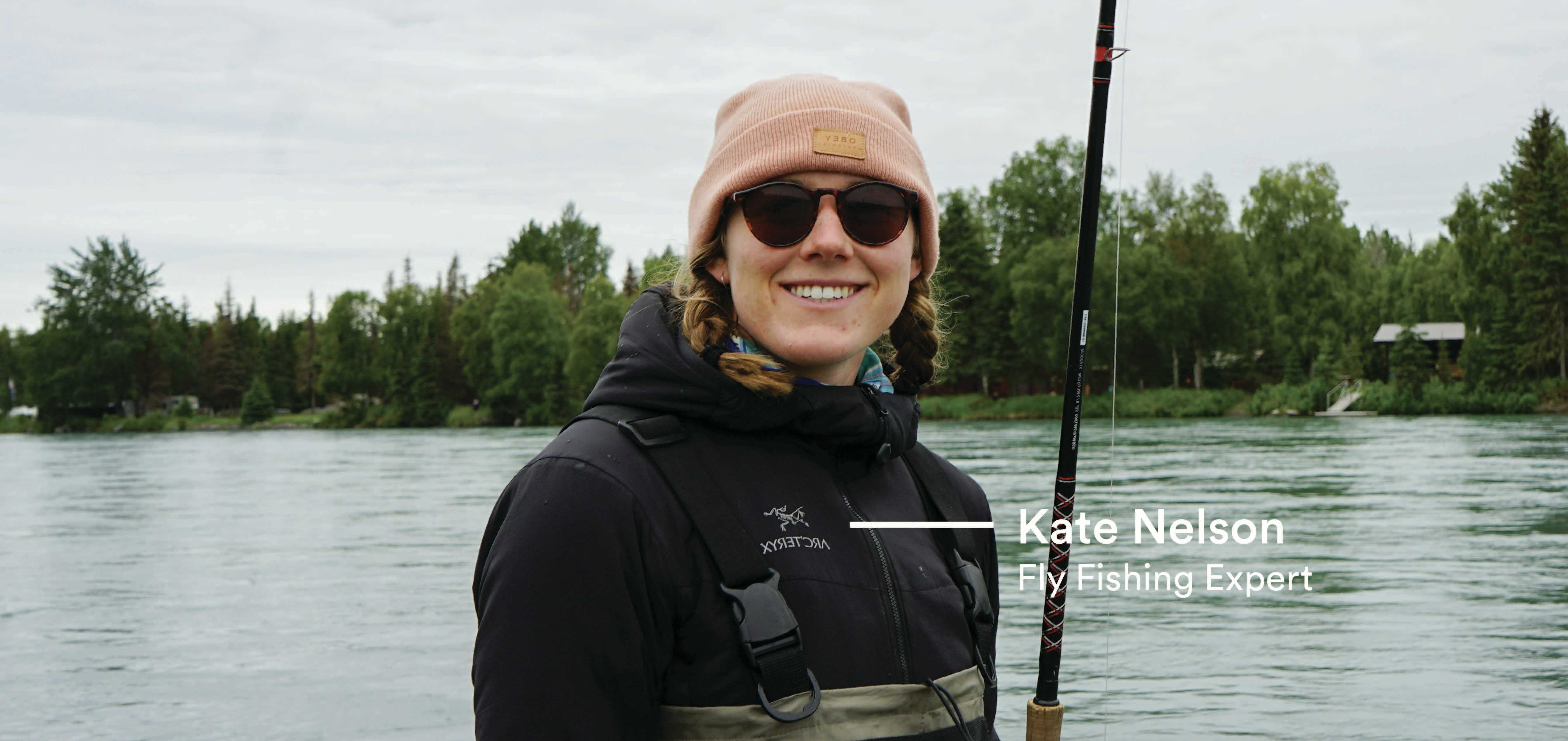 Fly Fishing Expert Kate Nelson smiles while standing at the waterfront. 